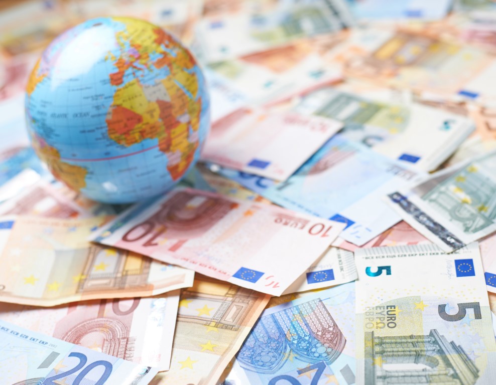 différentes monnaies et un globe
